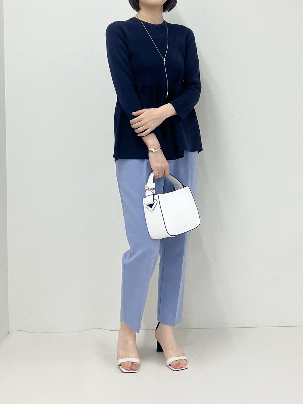 ブルー系のその他パンツ、ホワイト系のショルダーバッグ、ブルー系のニット/セーターを着用したレディースの冬コーディネートの4枚目の写真
