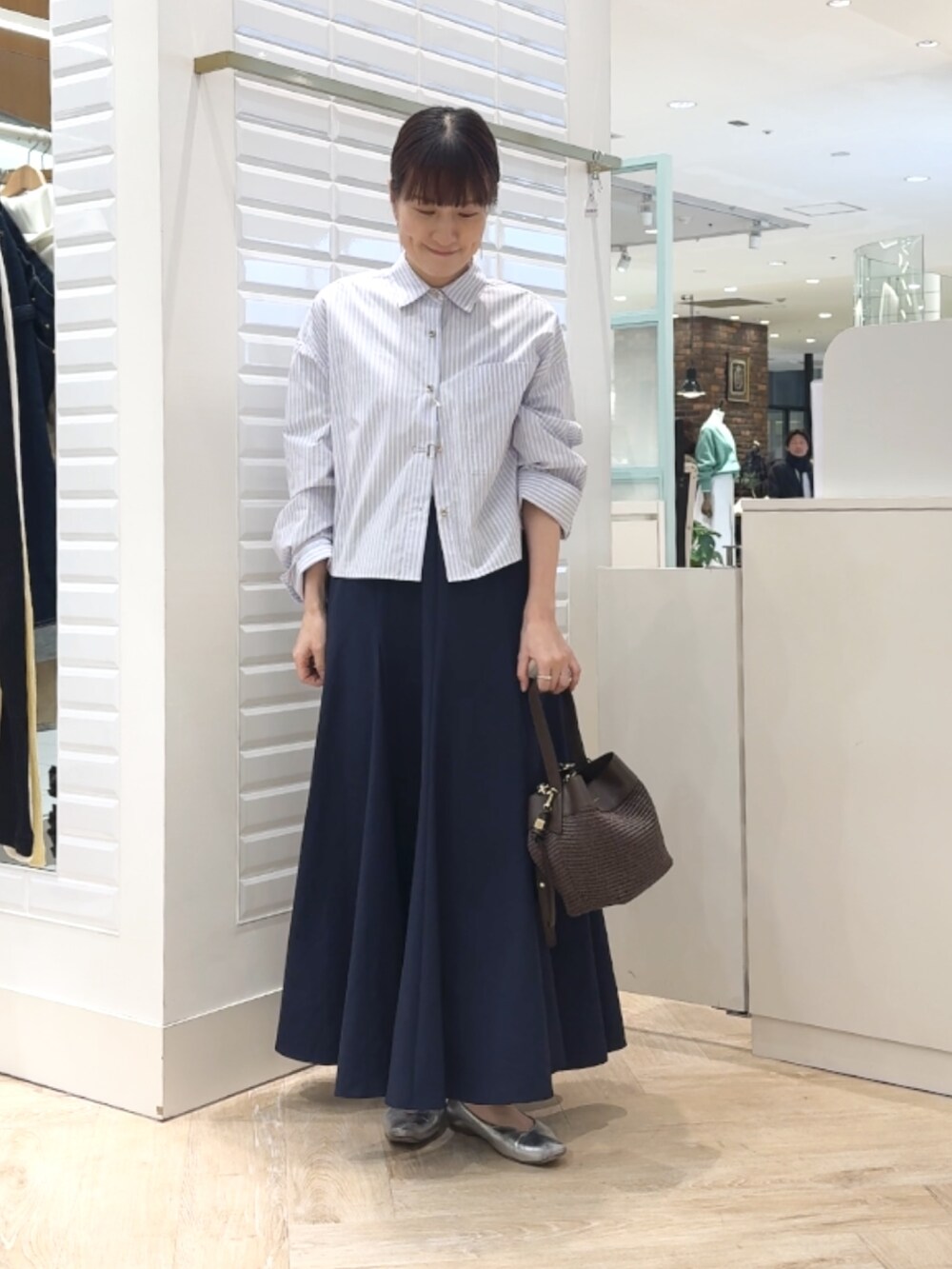 ブルー系のシャツ/ブラウス、ブルー系のスカート、ブラウン系のショルダーバッグを着用したレディースの春コーディネートの6枚目の写真