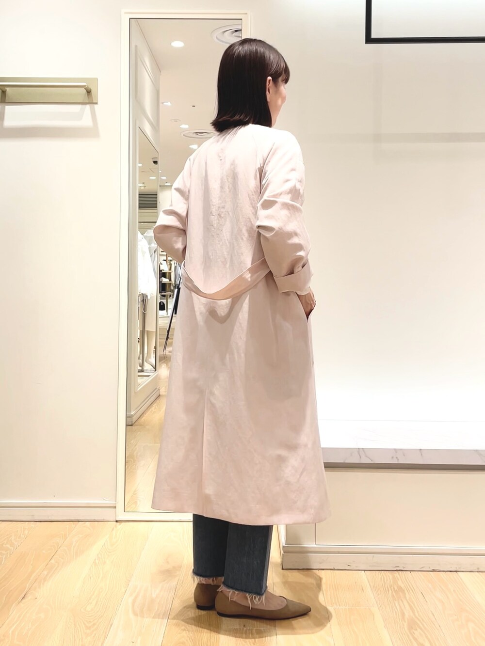ベージュ系のニット/セーター、ピンク系のノーカラーコート、ホワイト系のシャツ/ブラウスを着用したレディースの春コーディネートの7枚目の写真