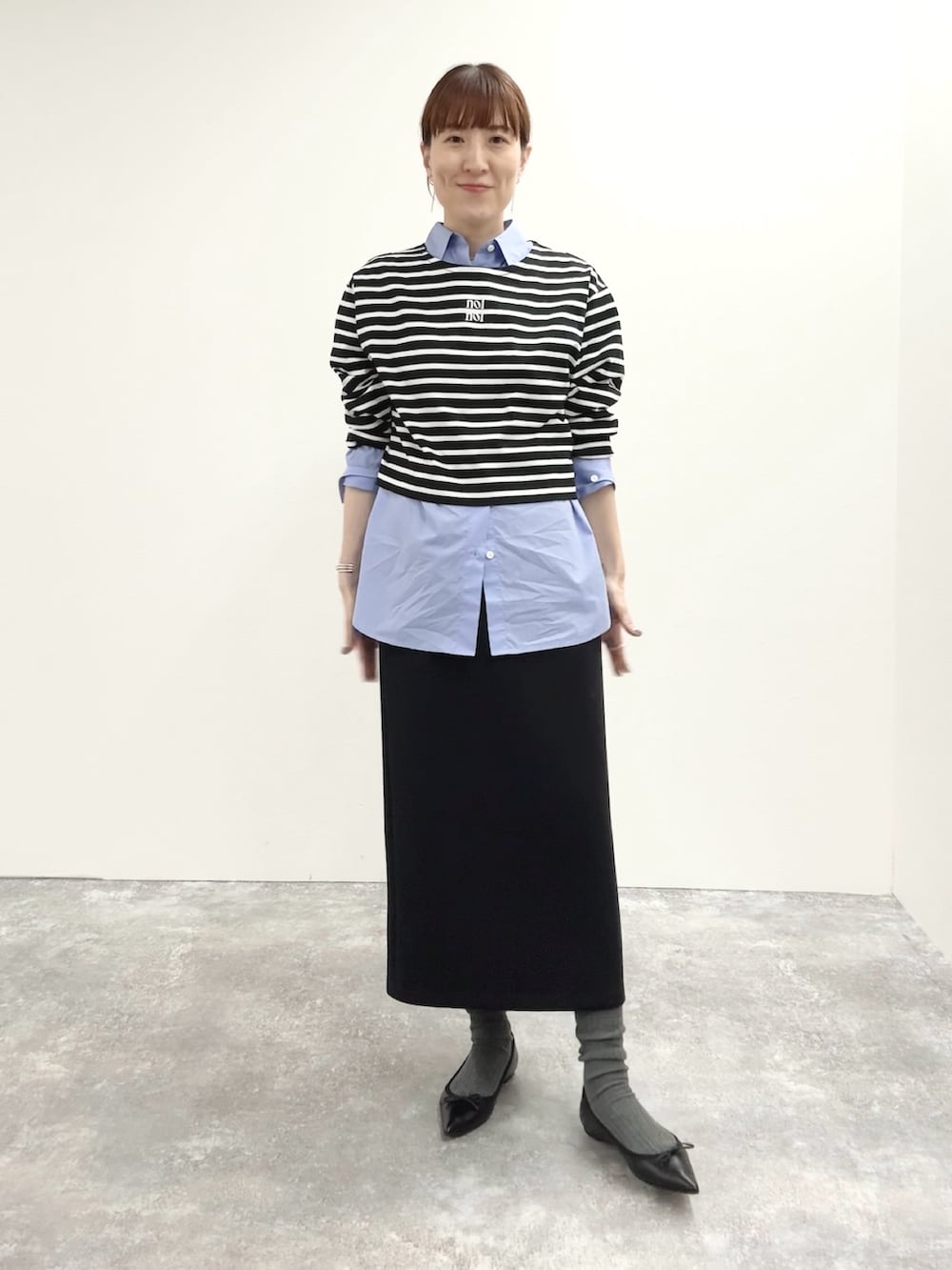 ブラック系のスカート、ブラック系のTシャツ/カットソー、グレー系のピーコートを着用したレディースの秋コーディネートの6枚目の写真