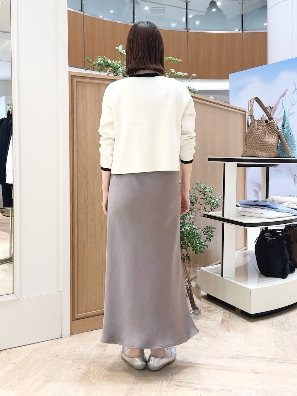 ベージュ系のトートバッグ、ホワイト系のシャツ/ブラウス、グリーン系のスカートを着用したレディースの春コーディネートの5枚目の写真