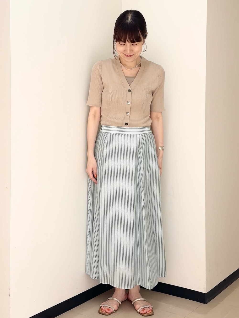 ブルー系のスカート、ベージュ系のカーディガン/ボレロ、ベージュ系のタンクトップを着用したレディースの夏コーディネートの7枚目の写真