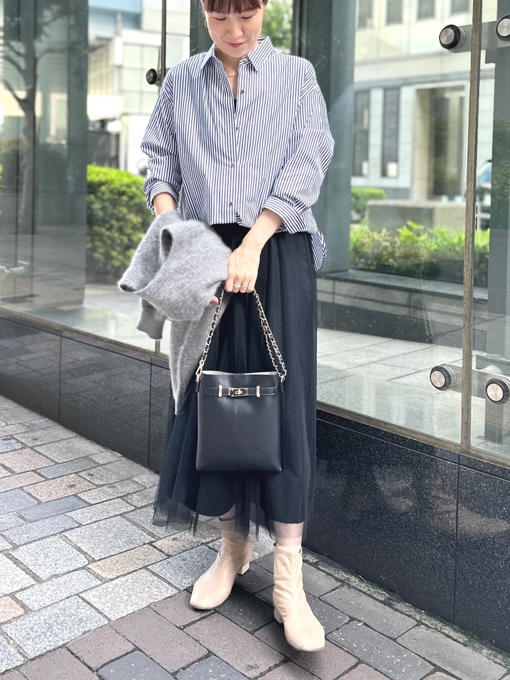 ブラック系のワンピース、ブラック系のショルダーバッグ、ブルー系のシャツ/ブラウスを着用したレディースの秋コーディネートの4枚目の写真