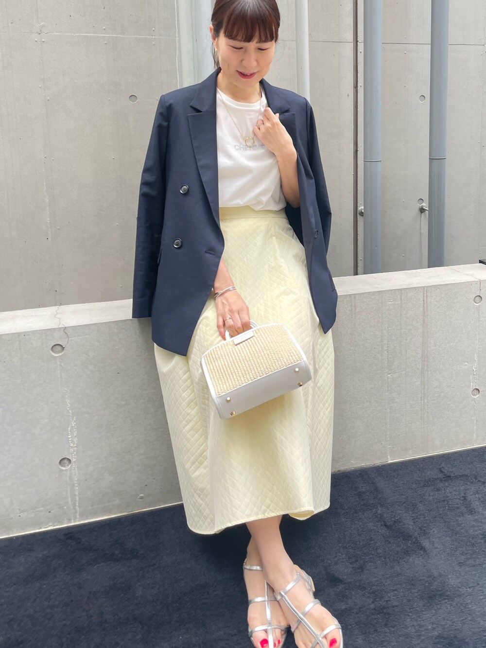 ブルー系のテーラードジャケット、ホワイト系のトートバッグ、イエロー系のスカートを着用したレディースの春コーディネートの3枚目の写真