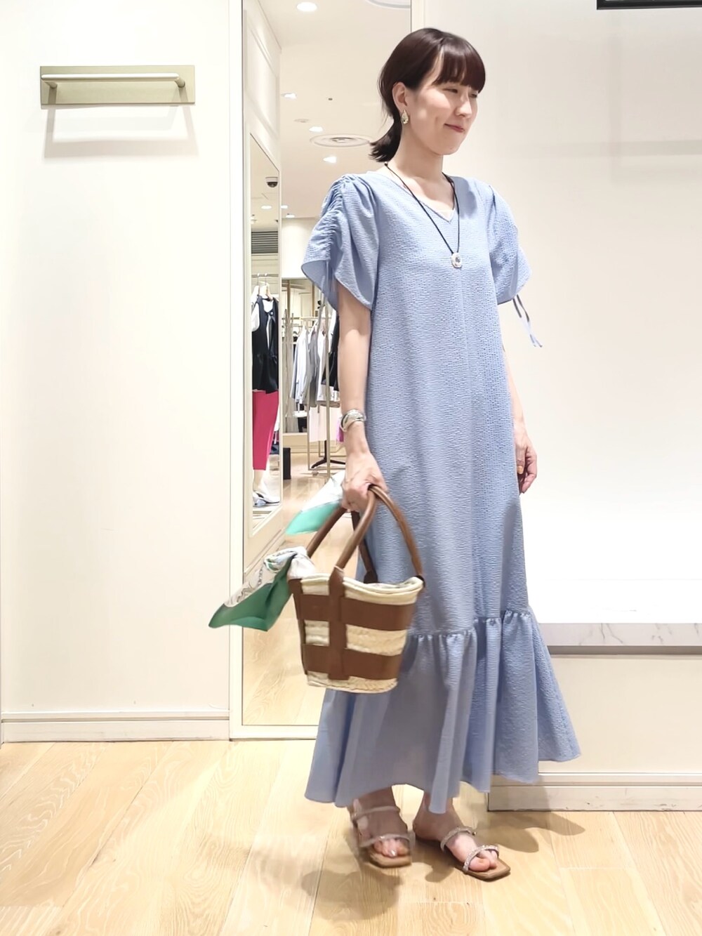 ブルー系のワンピース、グリーン系のバンダナ/スカーフ、ゴールド系のイヤリングを着用したレディースの春コーディネートの6枚目の写真