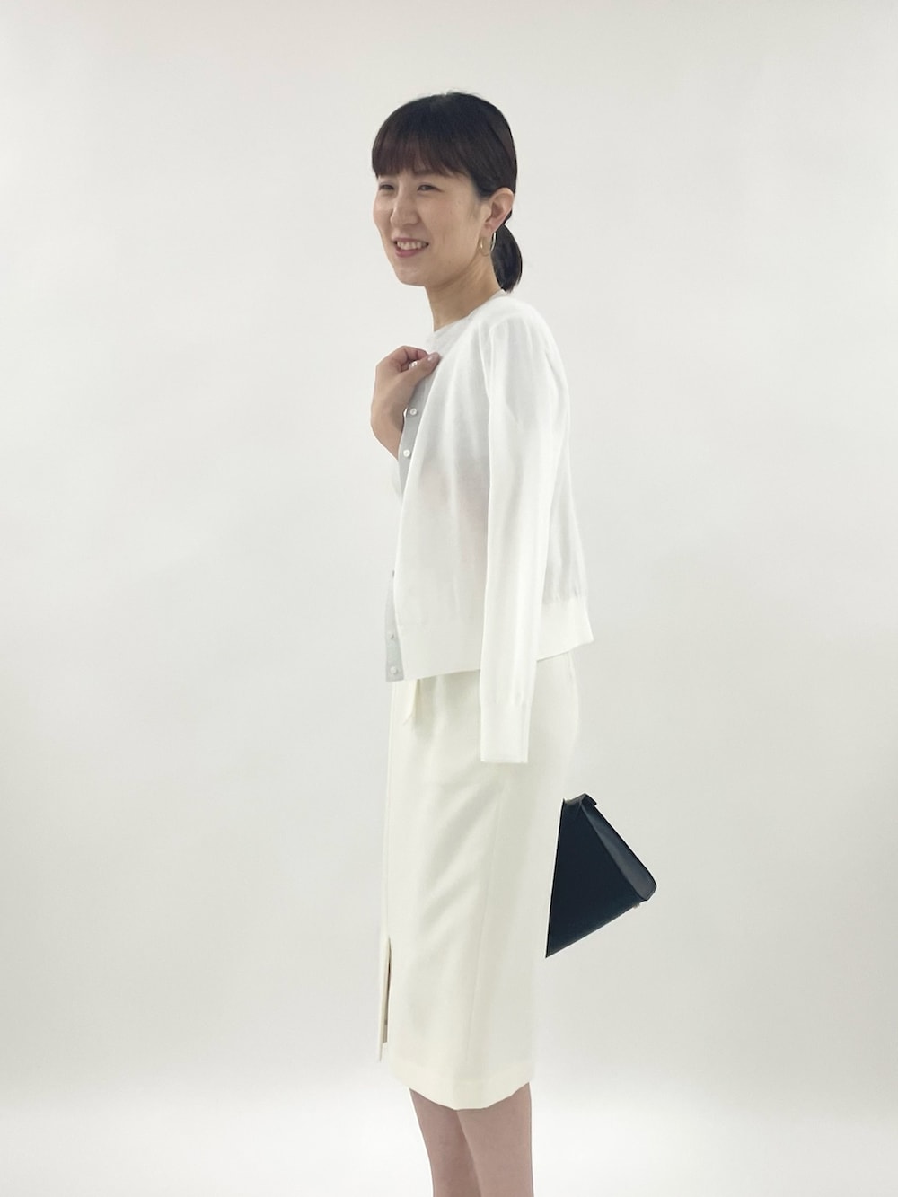 ゴールド系のサンダル、ブラック系のショルダーバッグ、シルバー系のニット/セーターを着用したレディースの春コーディネートの5枚目の写真