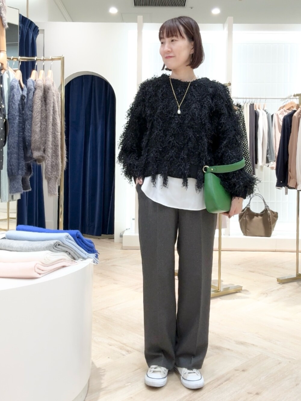 グレー系のその他パンツ、ホワイト系のシャツ/ブラウス、ブラック系のニット/セーターを着用したレディースの秋コーディネートの6枚目の写真