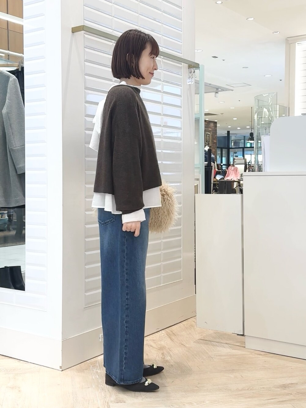 ベージュ系のショルダーバッグ、ホワイト系のシャツ/ブラウス、ブラウン系のニット/セーターを着用したレディースの冬コーディネートの5枚目の写真