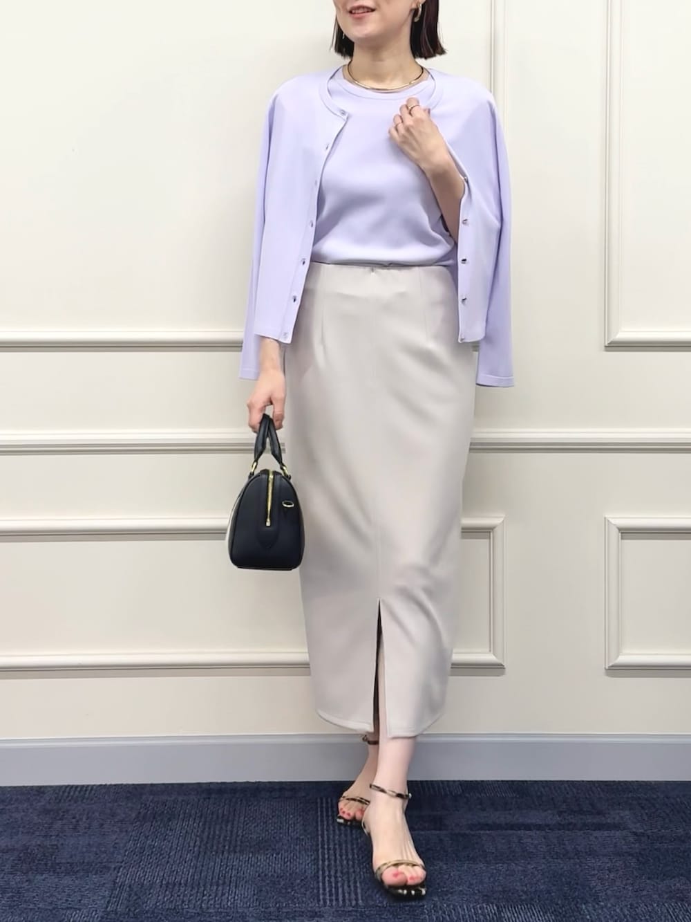 ブラック系のボストンバッグ、パープル系のカーディガン/ボレロ、パープル系のニット/セーターを着用したレディースの春コーディネートの5枚目の写真