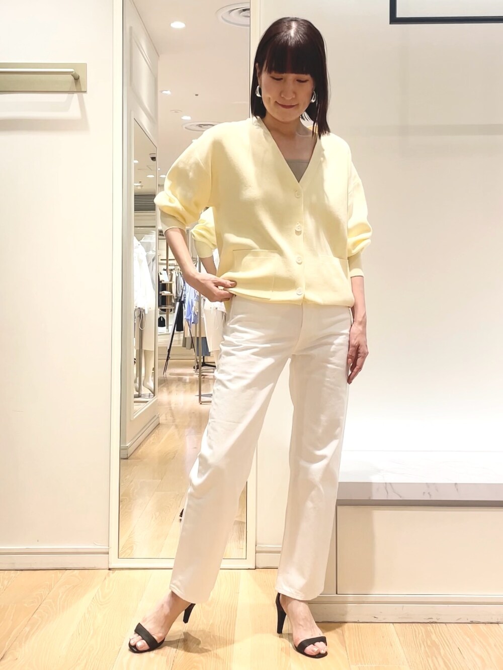 ベージュ系のニット/セーター、イエロー系のニット/セーターを着用したレディースの春コーディネートの5枚目の写真