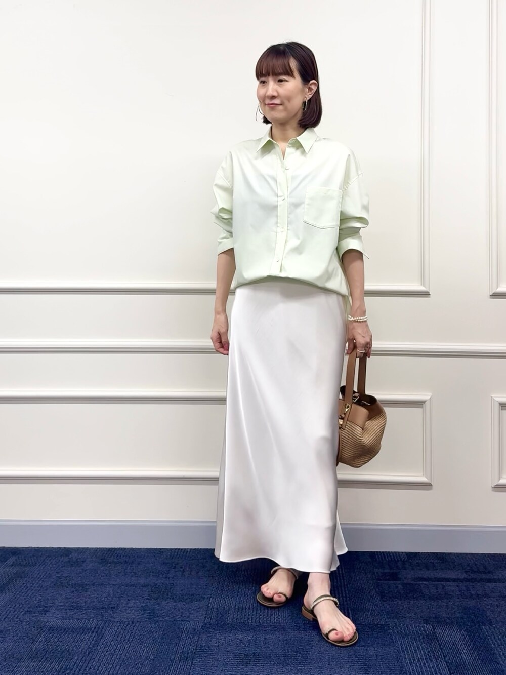 ブラウン系のボストンバッグ、ホワイト系のスカート、グリーン系のシャツ/ブラウスを着用したレディースの冬コーディネートの6枚目の写真