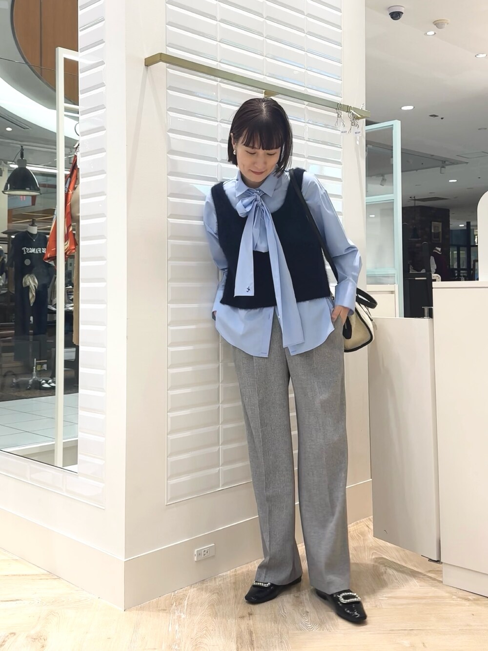 ホワイト系のボストンバッグ、ブルー系のベスト、ブルー系のシャツ/ブラウスを着用したレディースの秋コーディネートの9枚目の写真