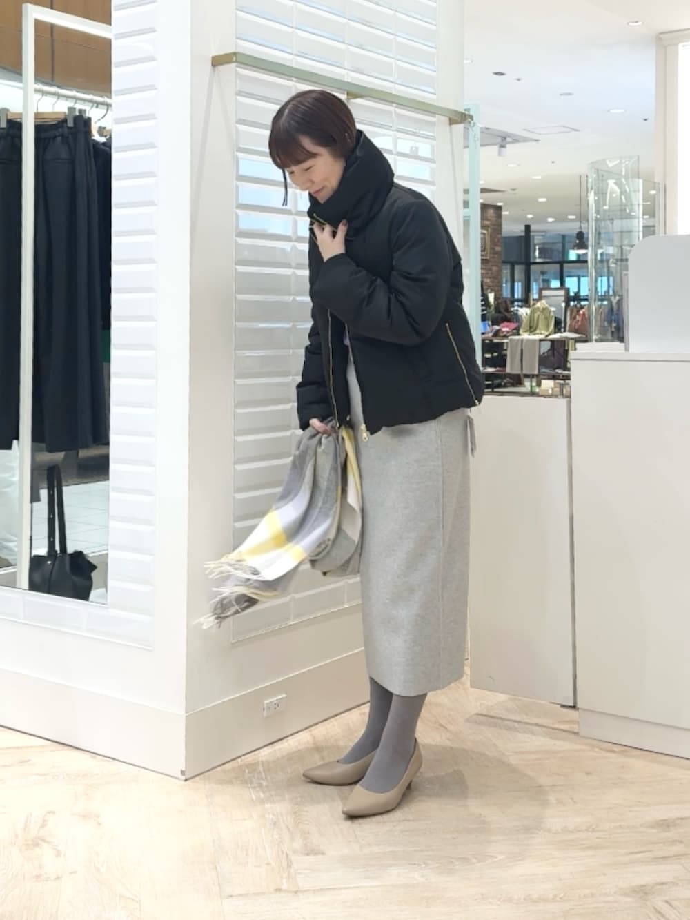 ブラック系のダウンジャケット/コート、パープル系のカーディガン/ボレロ、グレー系のスカートを着用したレディースの秋コーディネートの3枚目の写真