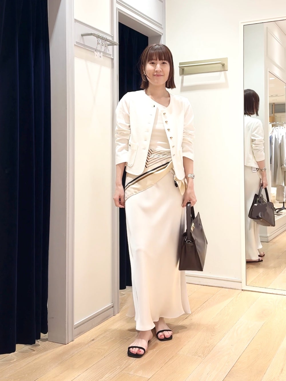 ホワイト系のタンクトップ、ホワイト系のノーカラージャケット、ホワイト系のスカートを着用したレディースの春コーディネートの8枚目の写真