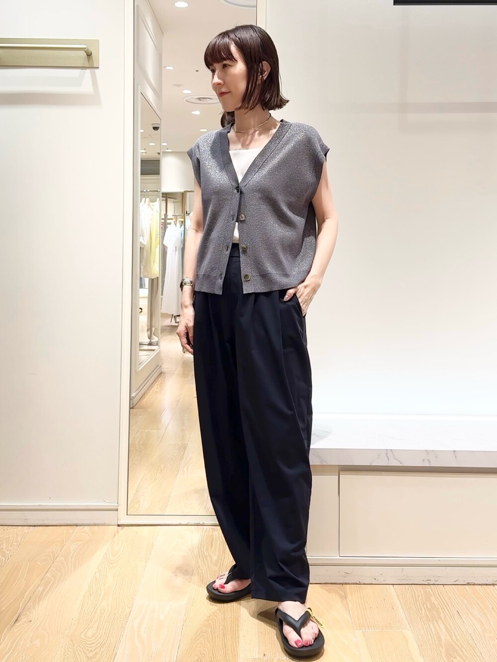 ブラック系のその他パンツ、ブラック系のサンダル、グレー系のベストを着用したレディースの夏コーディネートの2枚目の写真