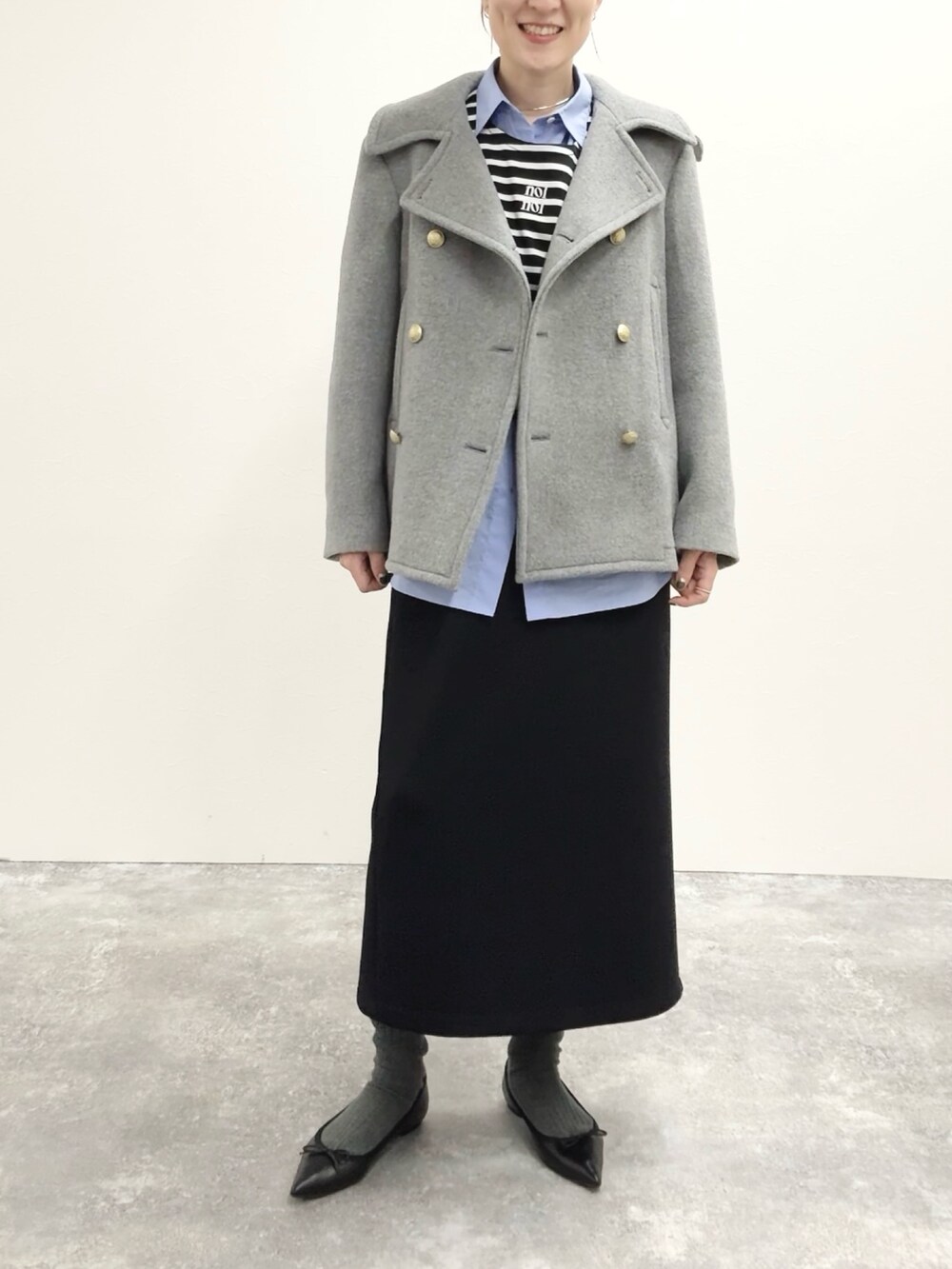 ブラック系のスカート、ブラック系のTシャツ/カットソー、グレー系のピーコートを着用したレディースの秋コーディネートの5枚目の写真