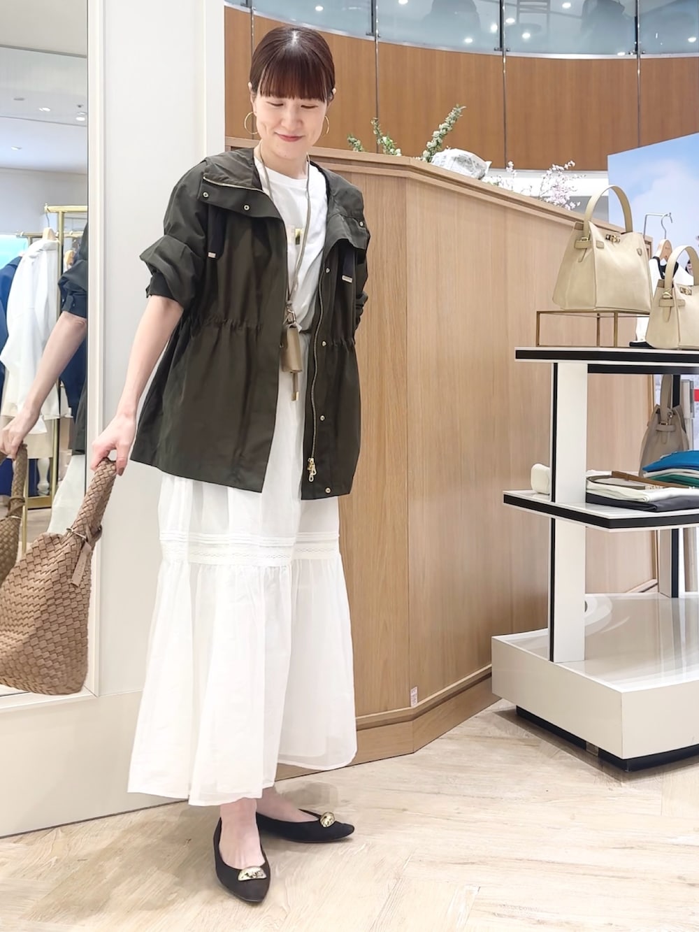 ブラウン系のショルダーバッグ、グレー系のブルゾン、ホワイト系のTシャツ/カットソーを着用したレディースの春コーディネートの6枚目の写真