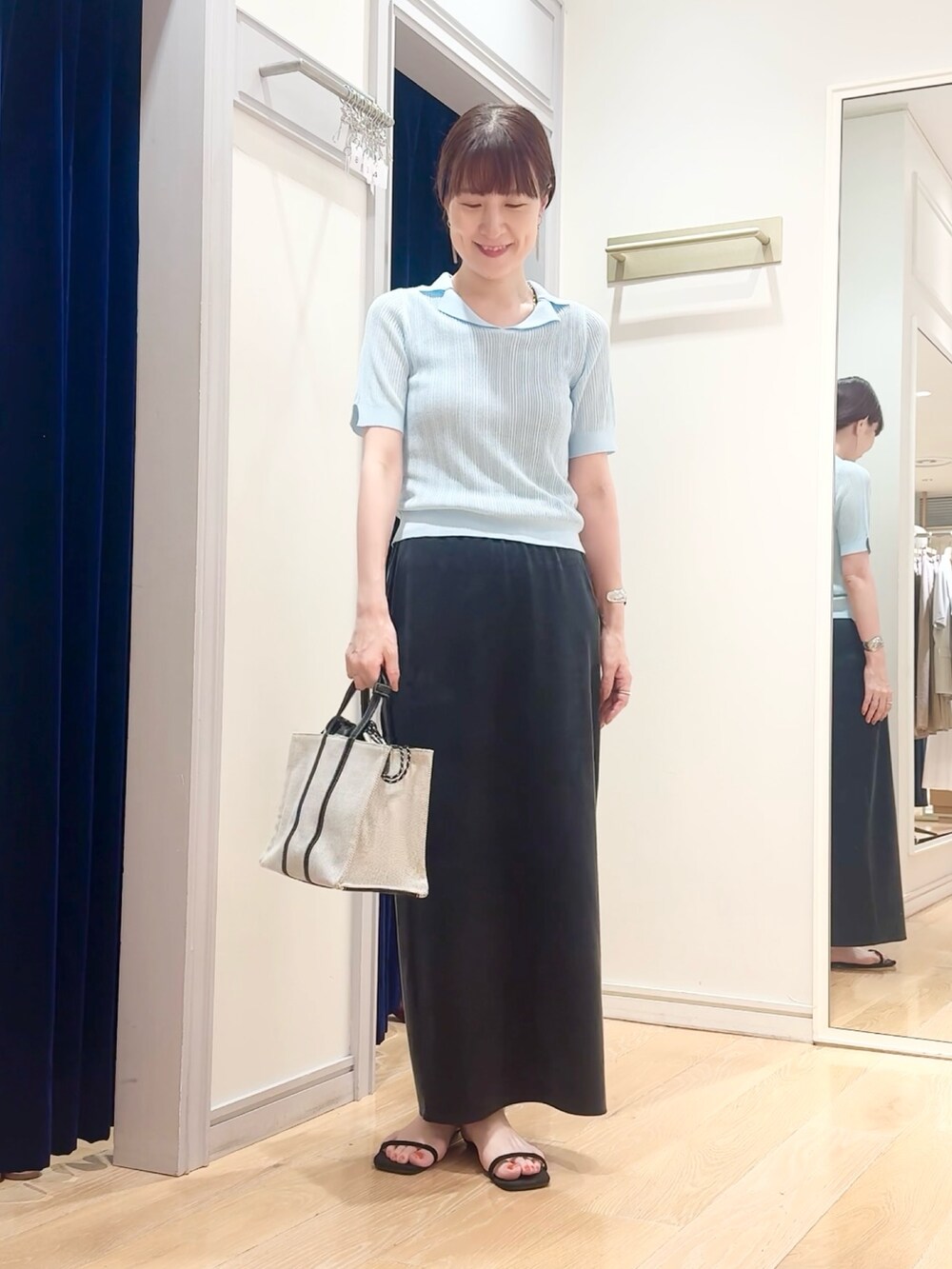 ブラック系のスカート、ベージュ系のタンクトップ、ブルー系のニット/セーターを着用したレディースの夏コーディネートの9枚目の写真