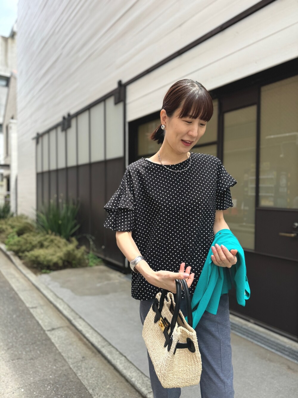 ゴールド系のサンダル、ブルー系のその他パンツ、ブラック系のかごバッグを着用したレディースの春コーディネートの2枚目の写真