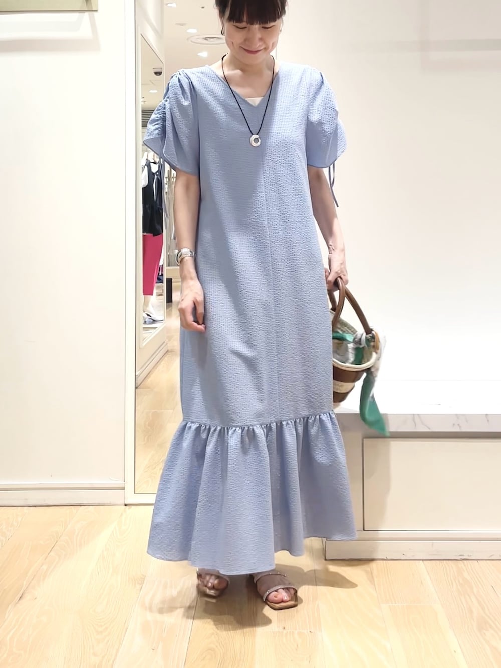 ブルー系のワンピース、グリーン系のバンダナ/スカーフ、ゴールド系のイヤリングを着用したレディースの春コーディネートの9枚目の写真