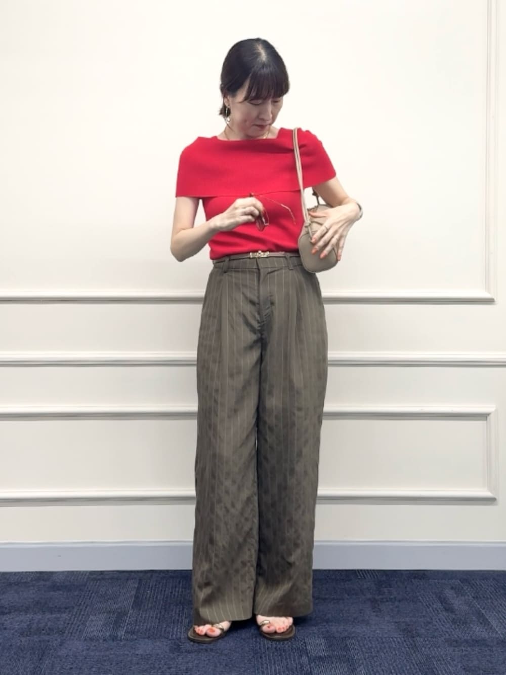 レッド系のニット/セーター、グリーン系のその他パンツ、ベージュ系のショルダーバッグを着用したレディースの夏コーディネートの5枚目の写真