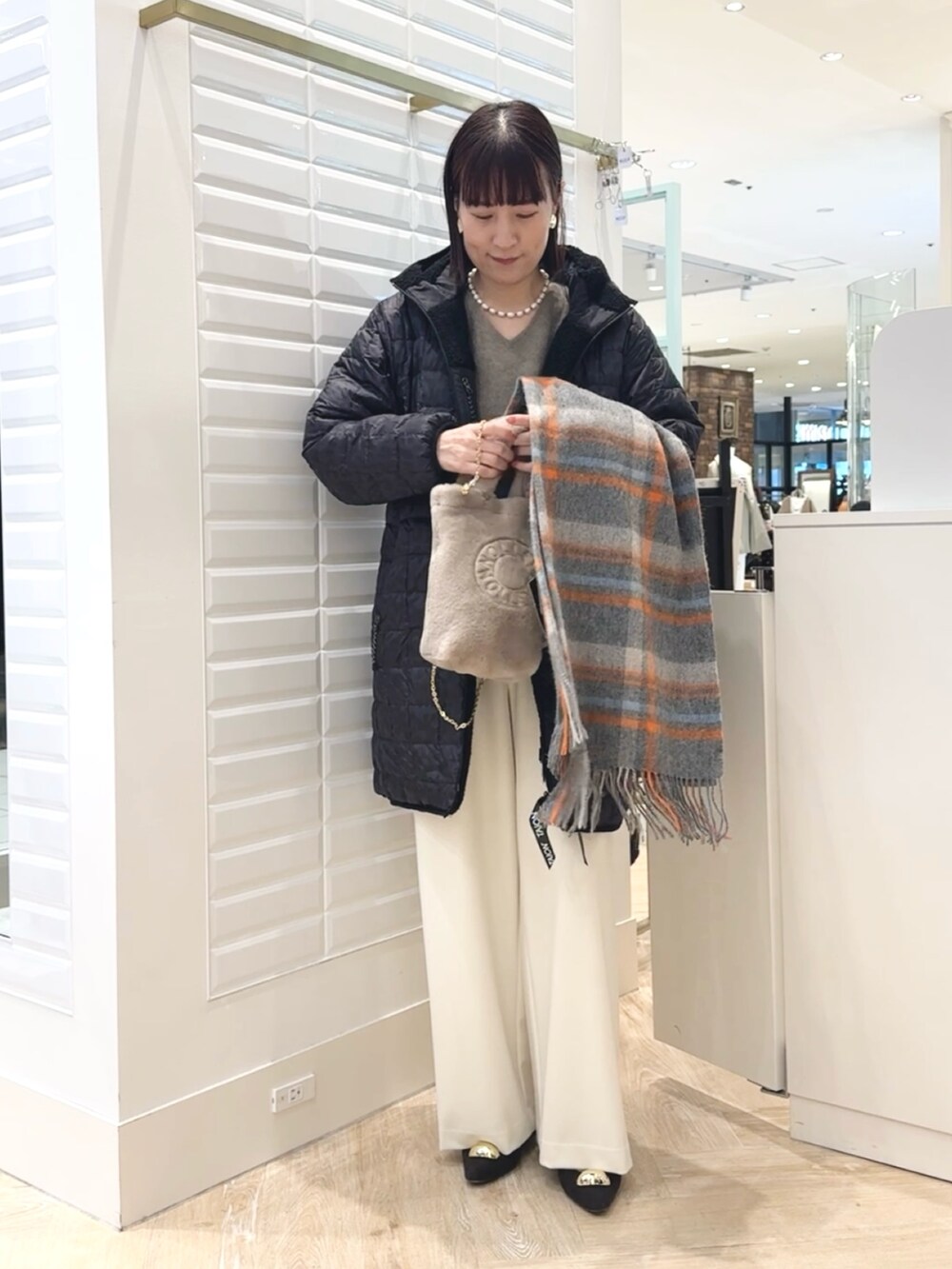 ホワイト系のその他パンツ、ベージュ系のトートバッグ、ブラック系のダウンジャケット/コートを着用したレディースの秋コーディネートの7枚目の写真