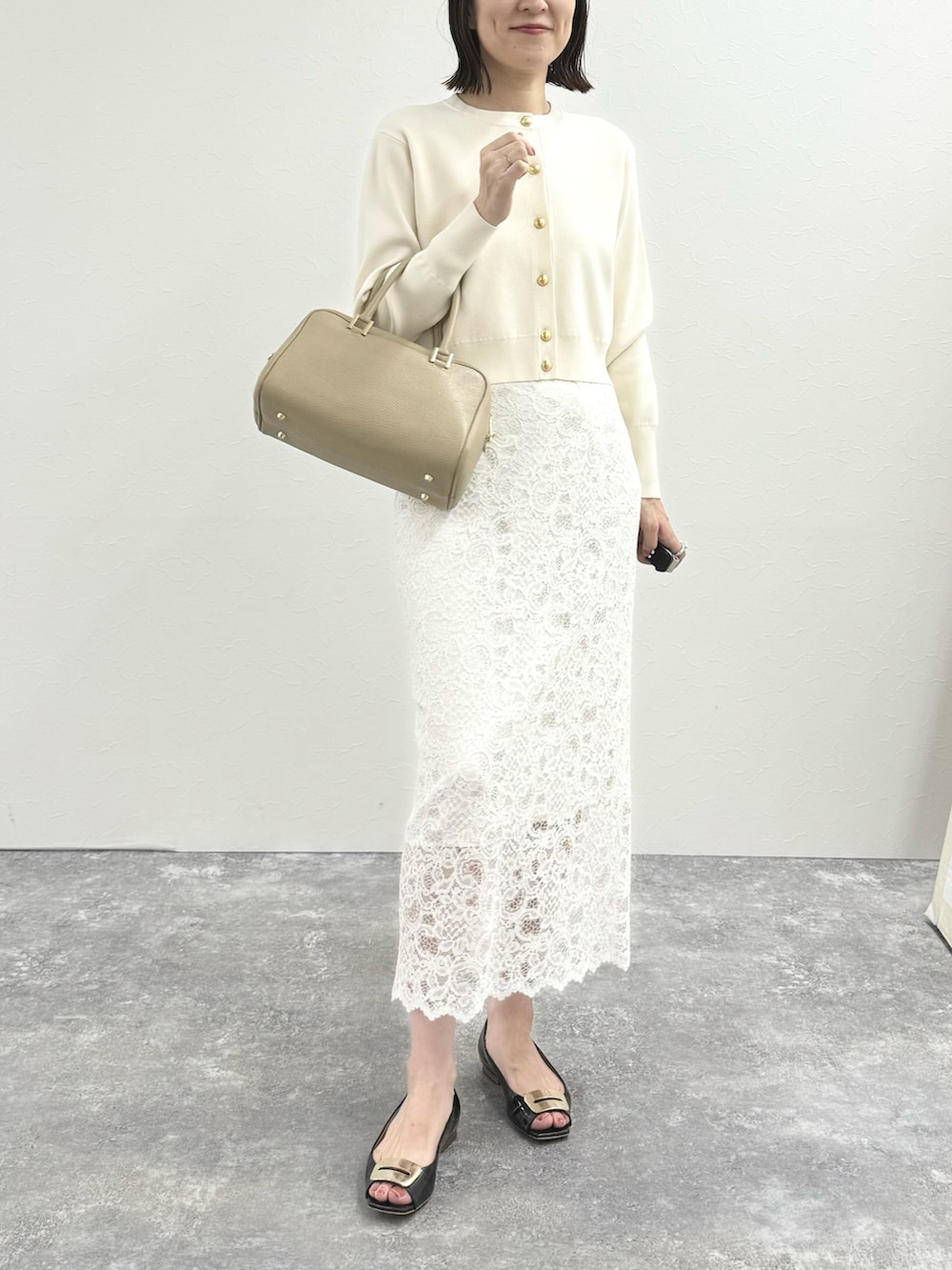 ホワイト系のカーディガン/ボレロ、ベージュ系のショルダーバッグ、ホワイト系のスカートを着用したレディースの秋コーディネートの6枚目の写真