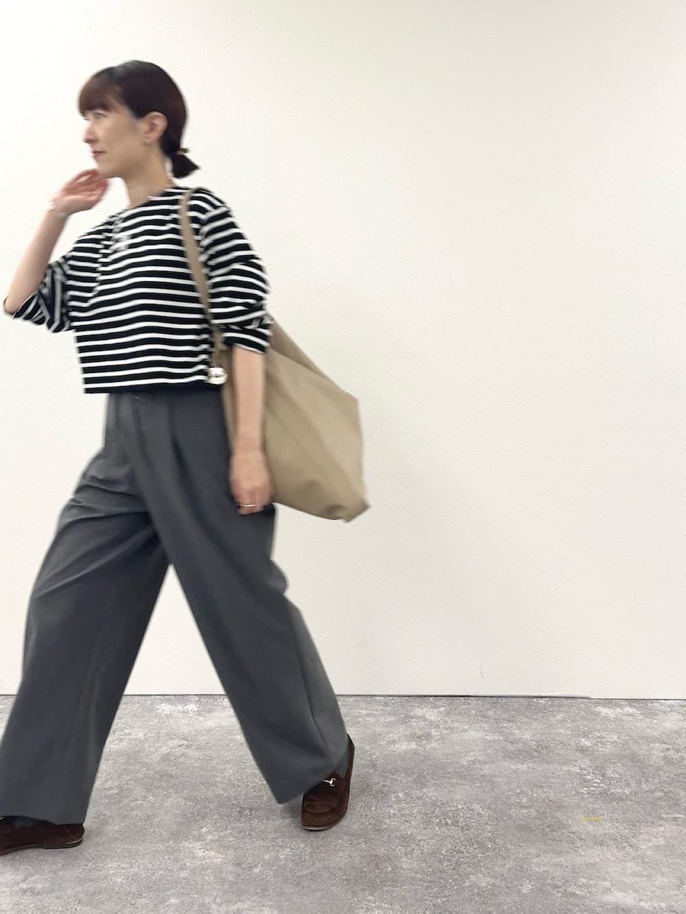 ブラック系のTシャツ/カットソー、ベージュ系のショルダーバッグ、グレー系のその他パンツを着用したレディースの秋コーディネートの3枚目の写真