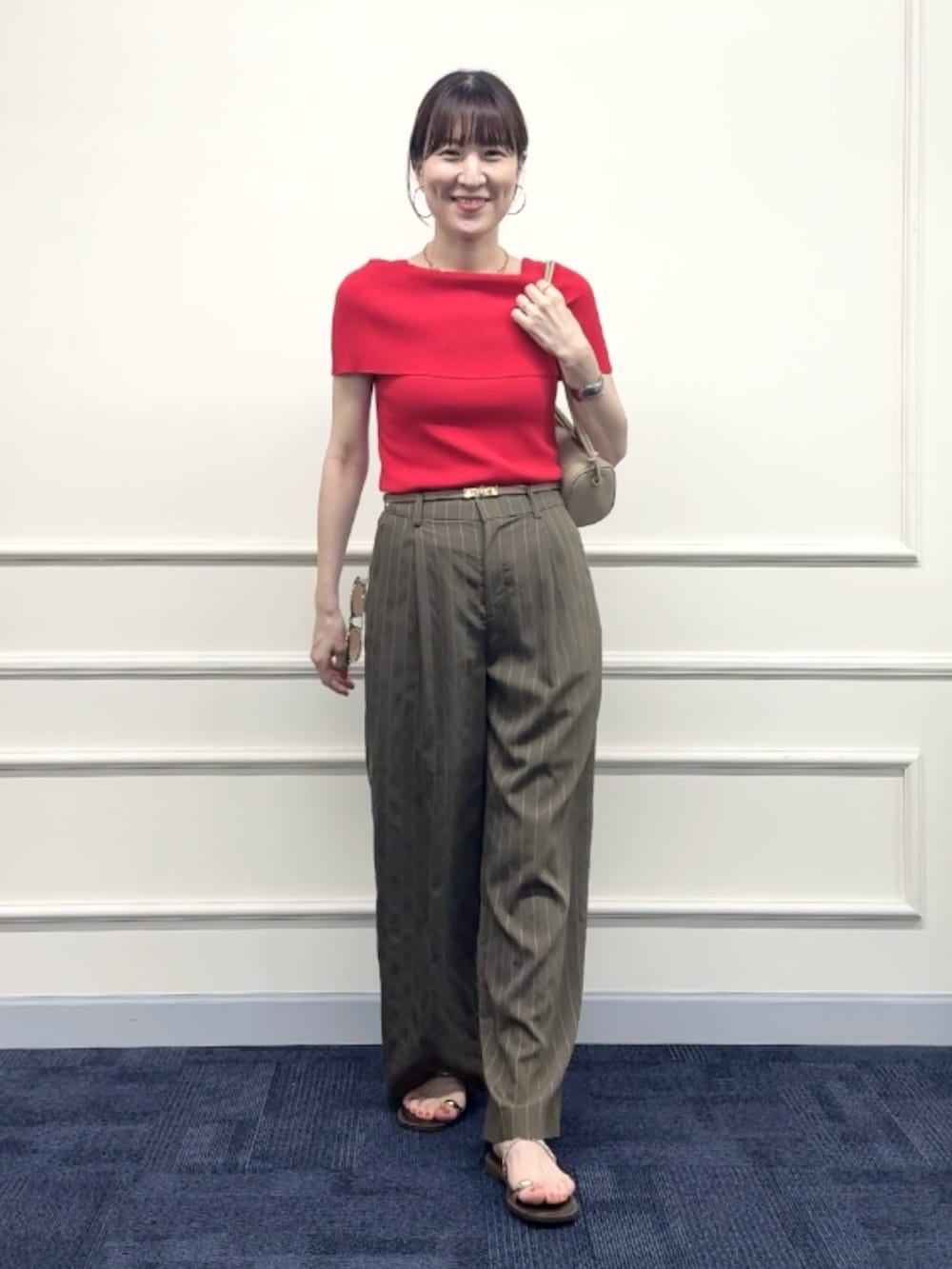 レッド系のニット/セーター、グリーン系のその他パンツ、ベージュ系のショルダーバッグを着用したレディースの夏コーディネートの2枚目の写真
