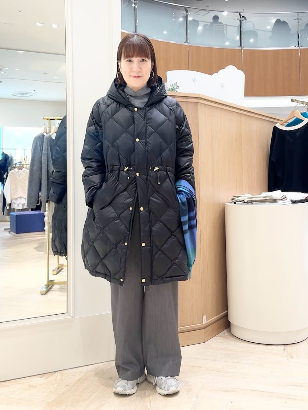 グレー系のその他パンツ、グレー系のニット/セーター、ブラック系のダウンジャケット/コートを着用したレディースの冬コーディネートの3枚目の写真