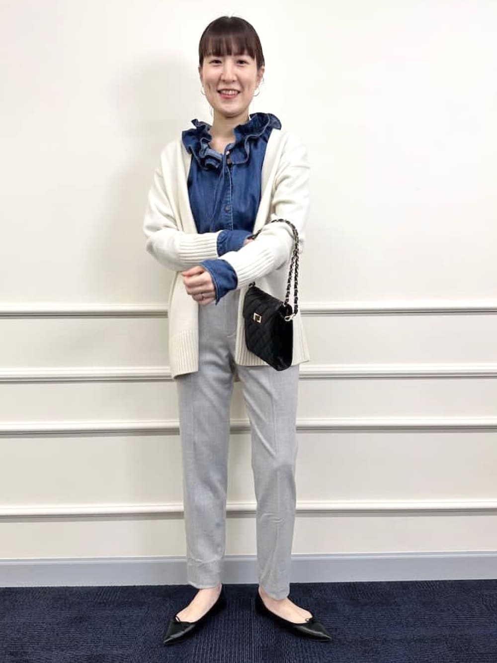 ブラック系のパンプス、グレー系のその他パンツ、ホワイト系のカーディガン/ボレロを着用したレディースの冬コーディネートの3枚目の写真