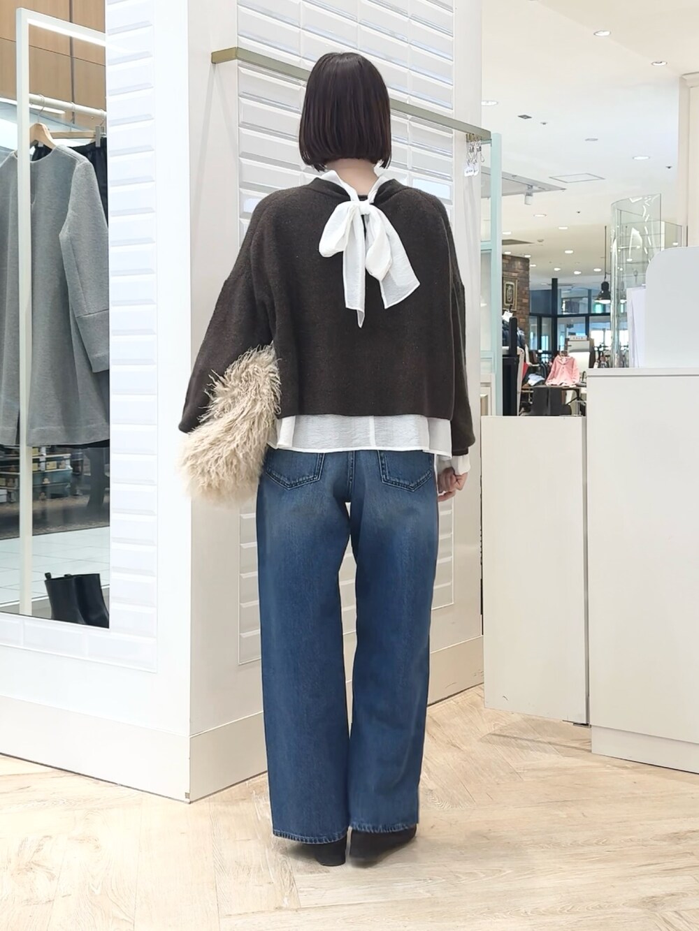 ベージュ系のショルダーバッグ、ホワイト系のシャツ/ブラウス、ブラウン系のニット/セーターを着用したレディースの冬コーディネートの6枚目の写真