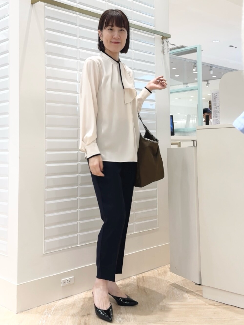 ブルー系のその他パンツ、ブラウン系のトートバッグ、ホワイト系のシャツ/ブラウスを着用したレディースの秋コーディネートの8枚目の写真