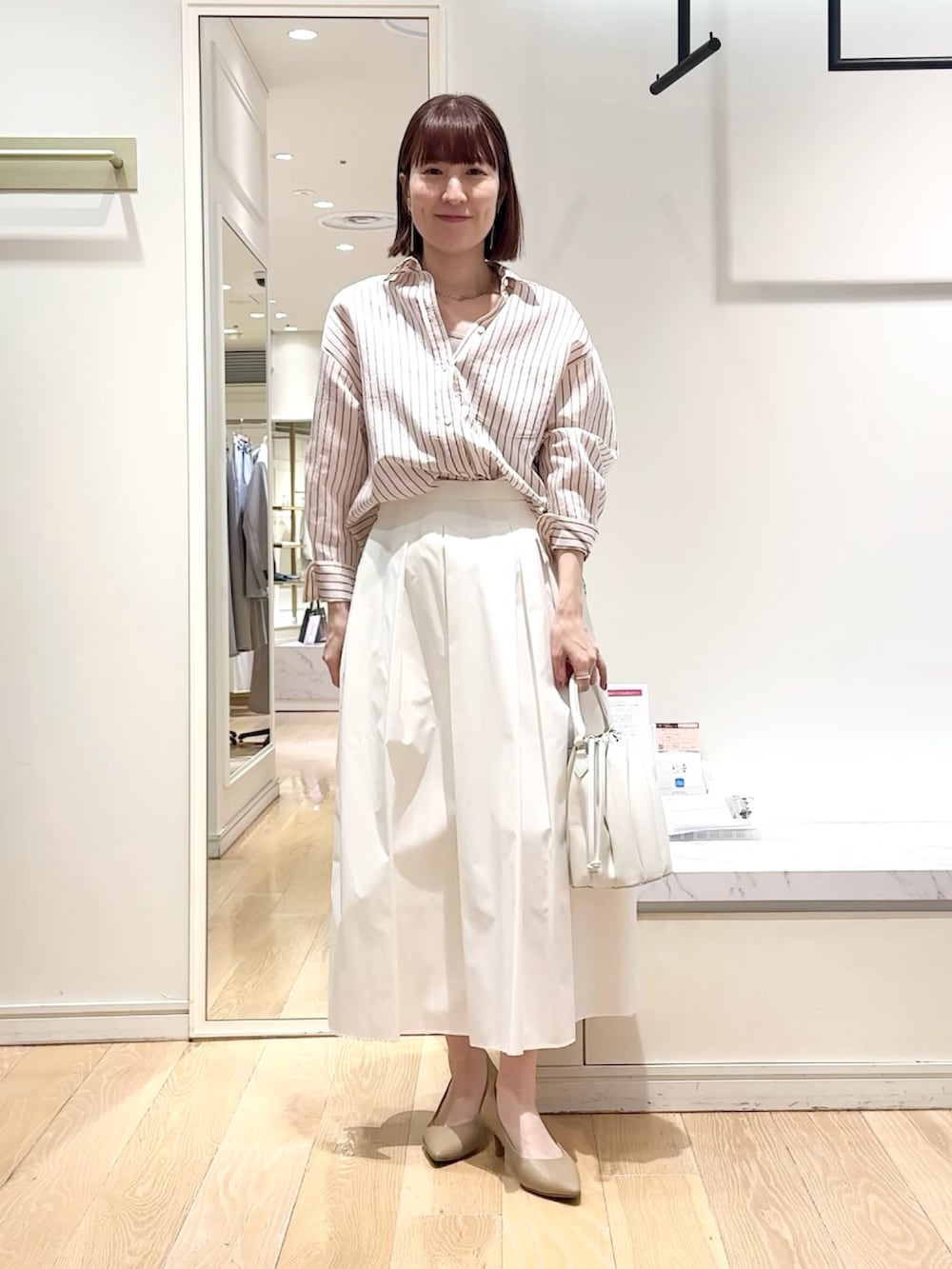 ホワイト系のスカート、ピンク系のシャツ/ブラウス、グレー系のネックレスを着用したレディースの春コーディネートの4枚目の写真