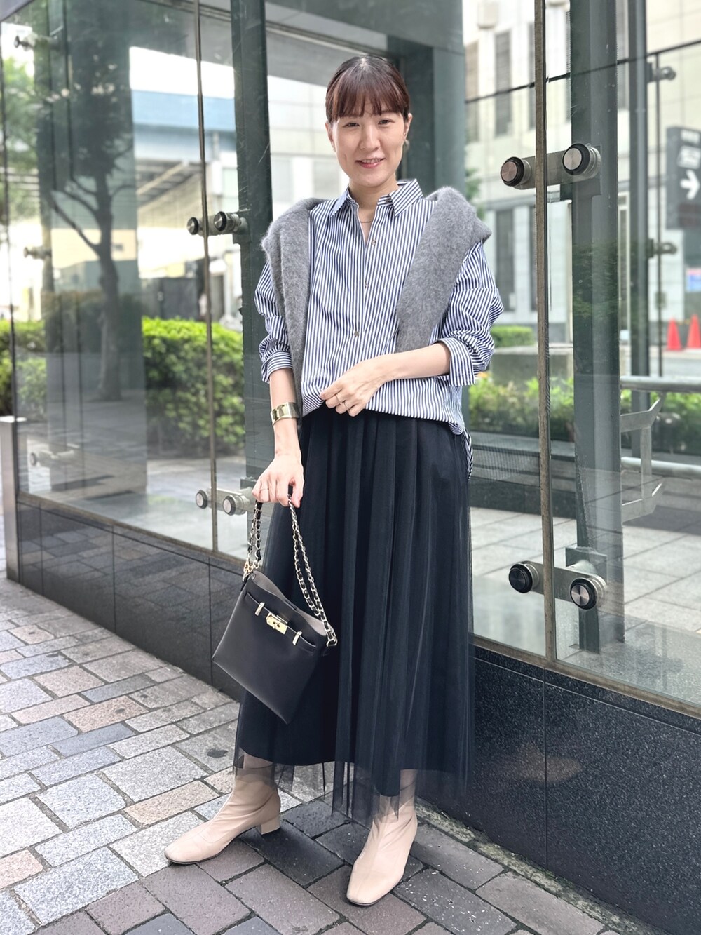 ブラック系のワンピース、ブラック系のショルダーバッグ、ブルー系のシャツ/ブラウスを着用したレディースの秋コーディネートの6枚目の写真