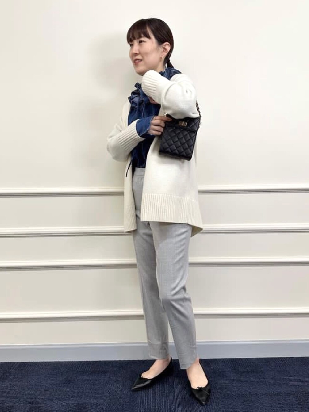 ブラック系のパンプス、グレー系のその他パンツ、ホワイト系のカーディガン/ボレロを着用したレディースの冬コーディネートの6枚目の写真