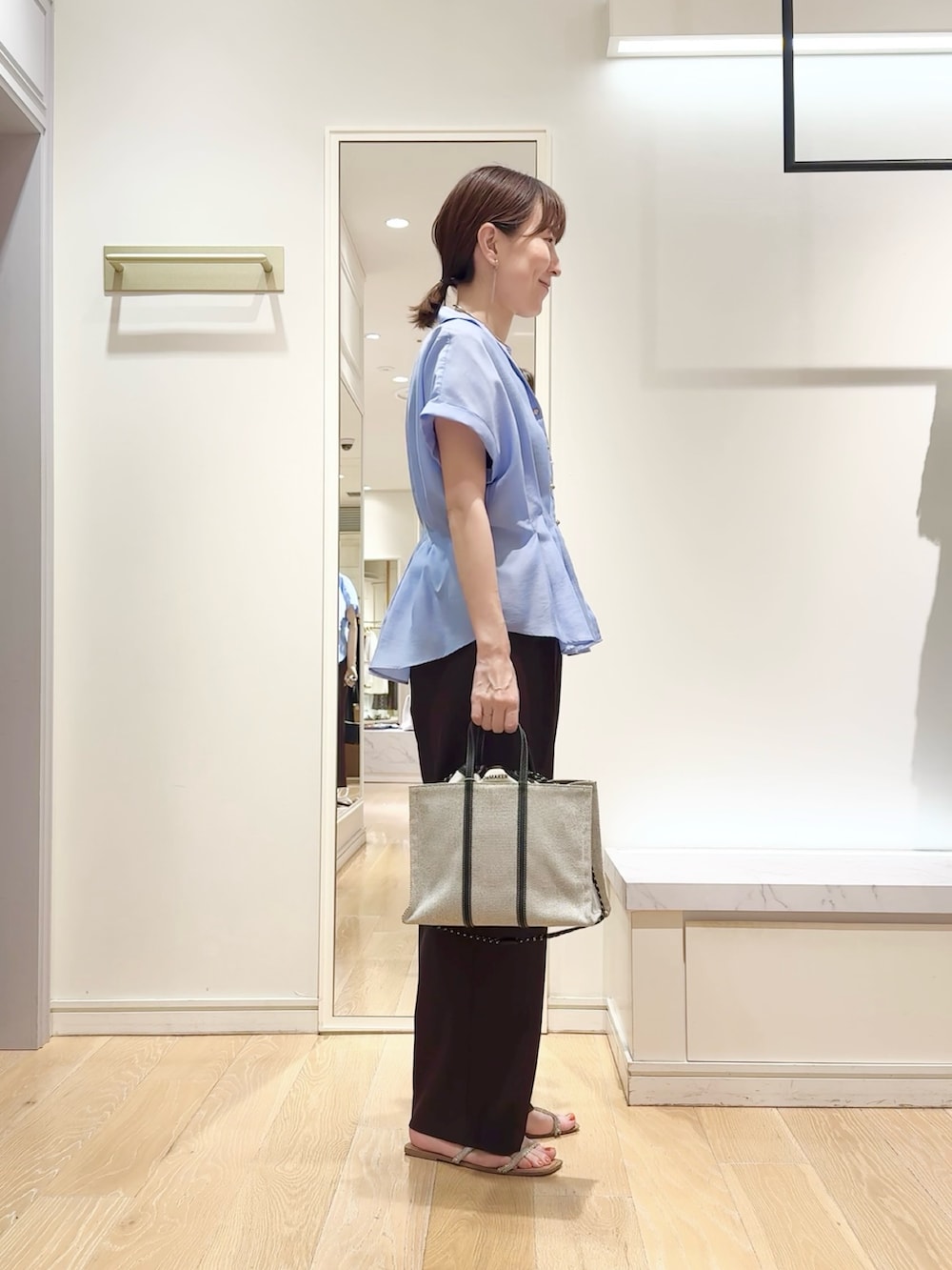 ブルー系のシャツ/ブラウス、ブラウン系のその他パンツ、ブラック系のトートバッグを着用したレディースの夏コーディネートの3枚目の写真