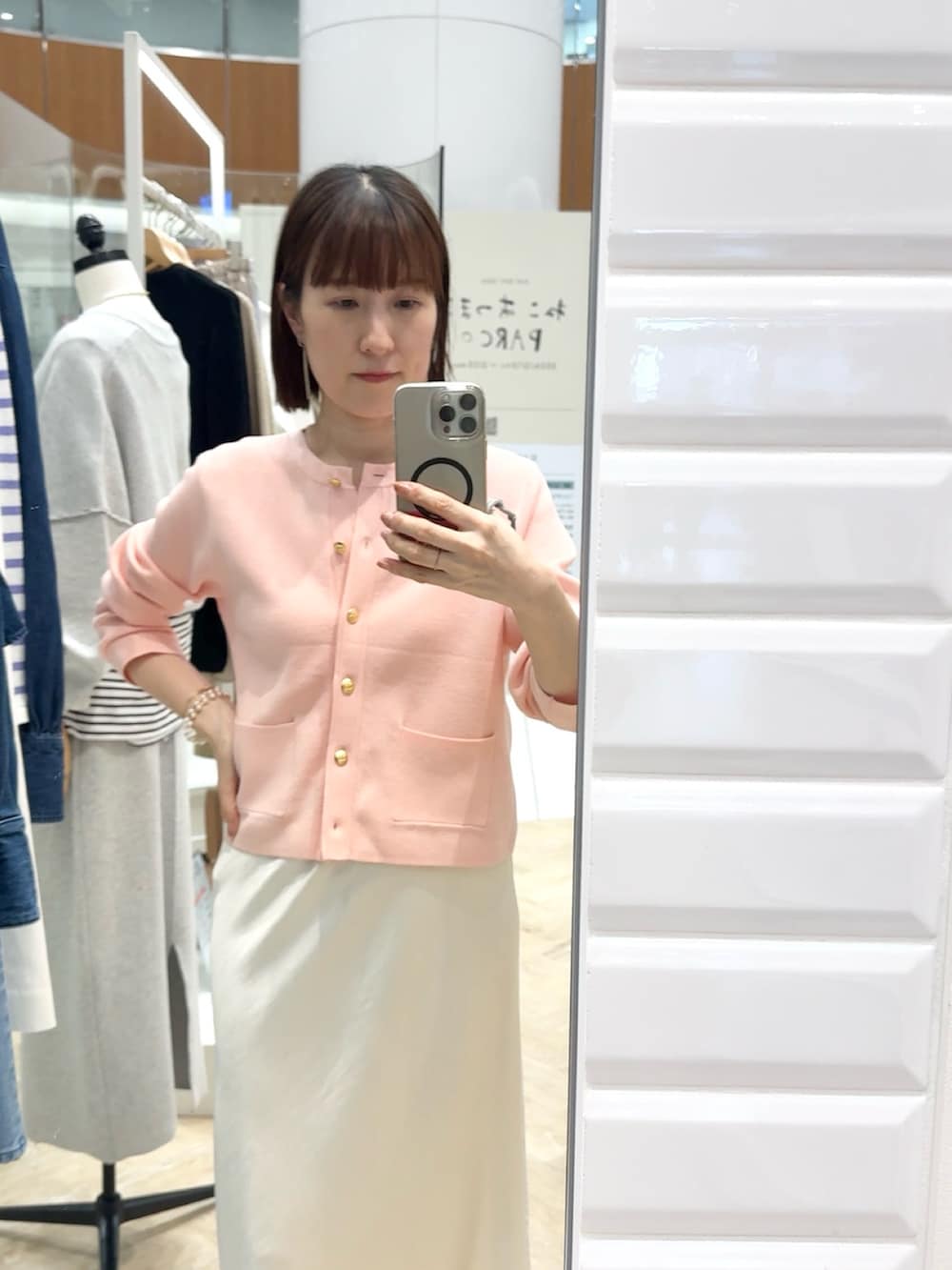 ホワイト系のスカート、ピンク系のカーディガン/ボレロ、ホワイト系のネックレスを着用したレディースの春コーディネートの3枚目の写真