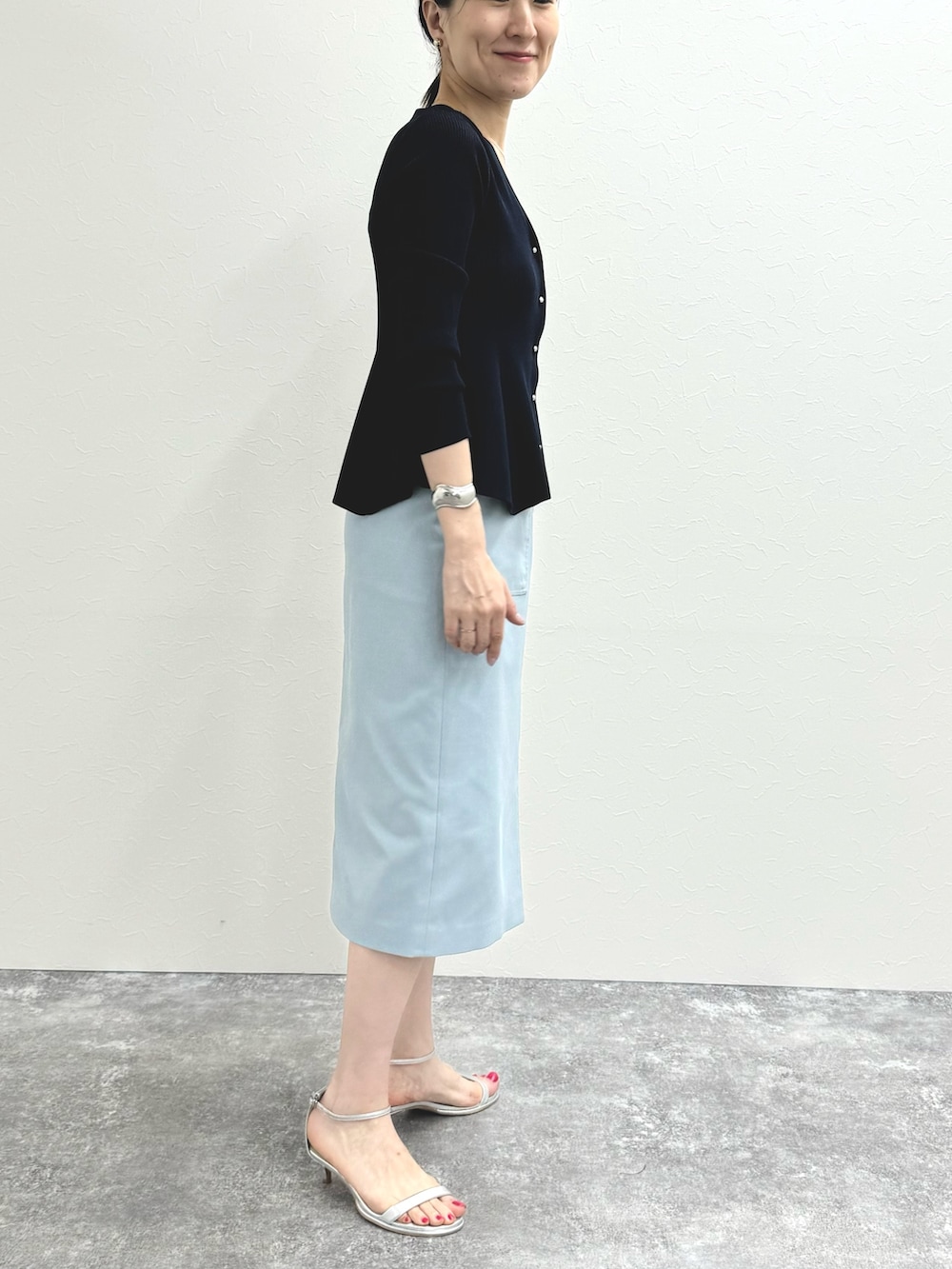 ブルー系のカーディガン/ボレロ、ブルー系のスカート、シルバー系のサンダルを着用したレディースの夏コーディネートの7枚目の写真