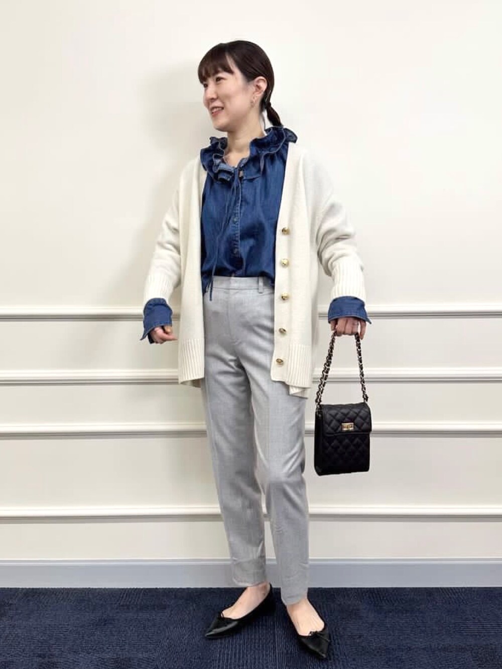 ブラック系のパンプス、グレー系のその他パンツ、ホワイト系のカーディガン/ボレロを着用したレディースの冬コーディネートの8枚目の写真