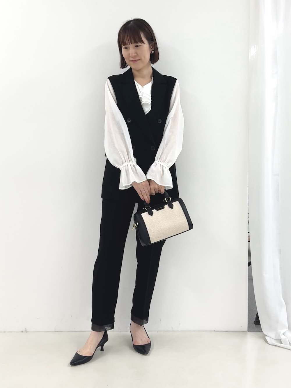 ブラック系のベスト、ホワイト系のシャツ/ブラウス、ブラック系のその他パンツを着用したレディースの冬コーディネートの4枚目の写真