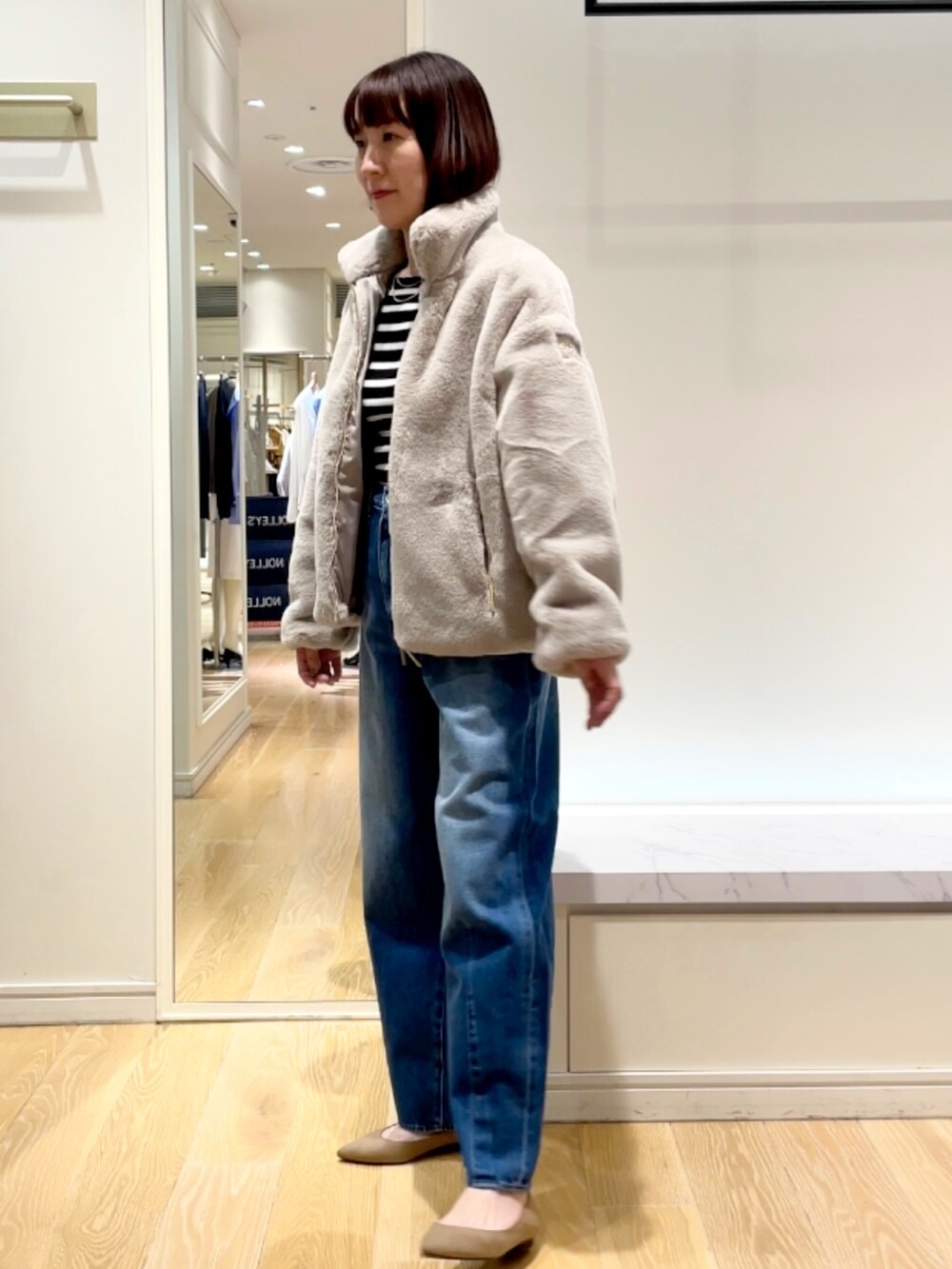 ブルー系のデニムパンツ、グレー系のブルゾン、ブラック系のニット/セーターを着用したレディースの秋コーディネートの7枚目の写真