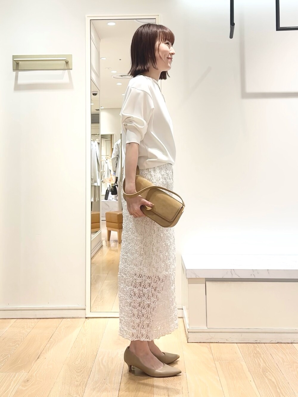 ホワイト系のTシャツ/カットソー、ホワイト系のスカート、ゴールド系のネックレスを着用したレディースの春コーディネートの6枚目の写真