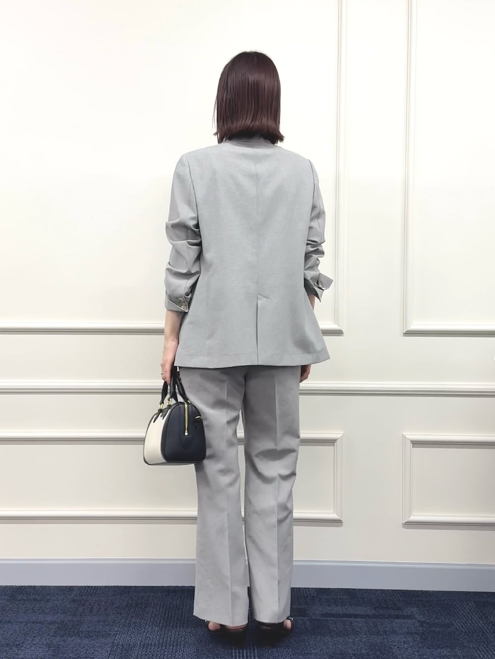 ブラック系のボストンバッグ、グレー系のその他パンツ、ホワイト系のTシャツ/カットソーを着用したレディースの春コーディネートの4枚目の写真