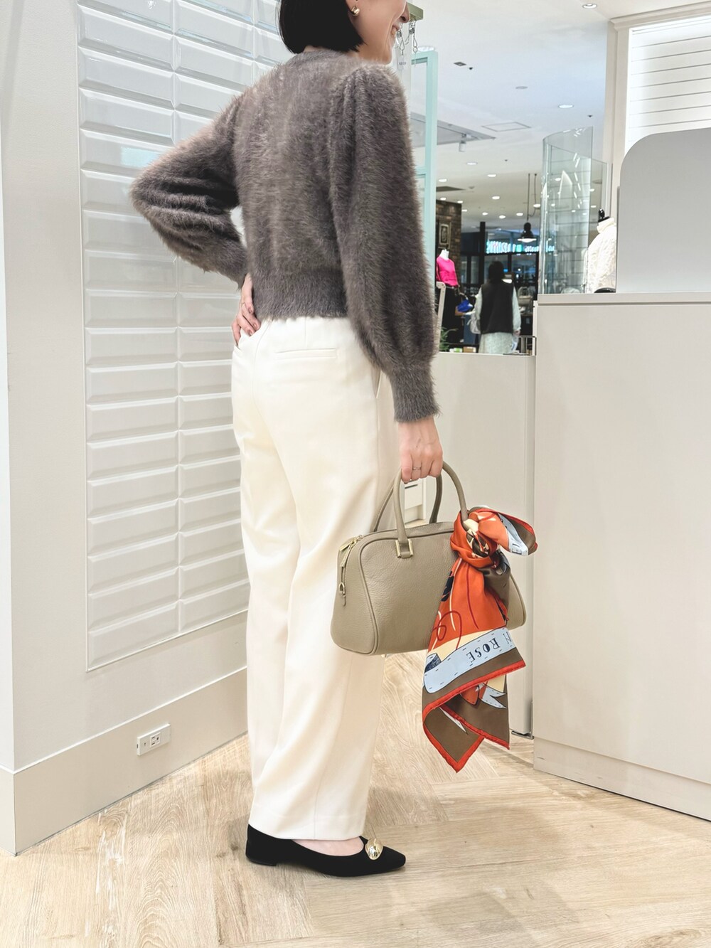 ベージュ系のショルダーバッグ、ブラウン系のカーディガン/ボレロ、ホワイト系のその他パンツを着用したレディースの秋コーディネートの3枚目の写真