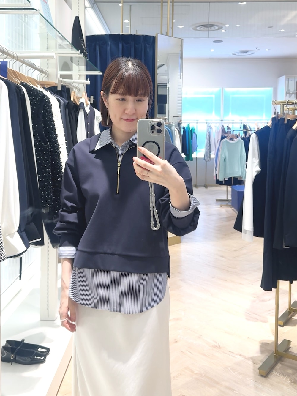 ホワイト系のスカート、ブルー系のスウェット、ブルー系のシャツ/ブラウスを着用したレディースの春コーディネートの2枚目の写真