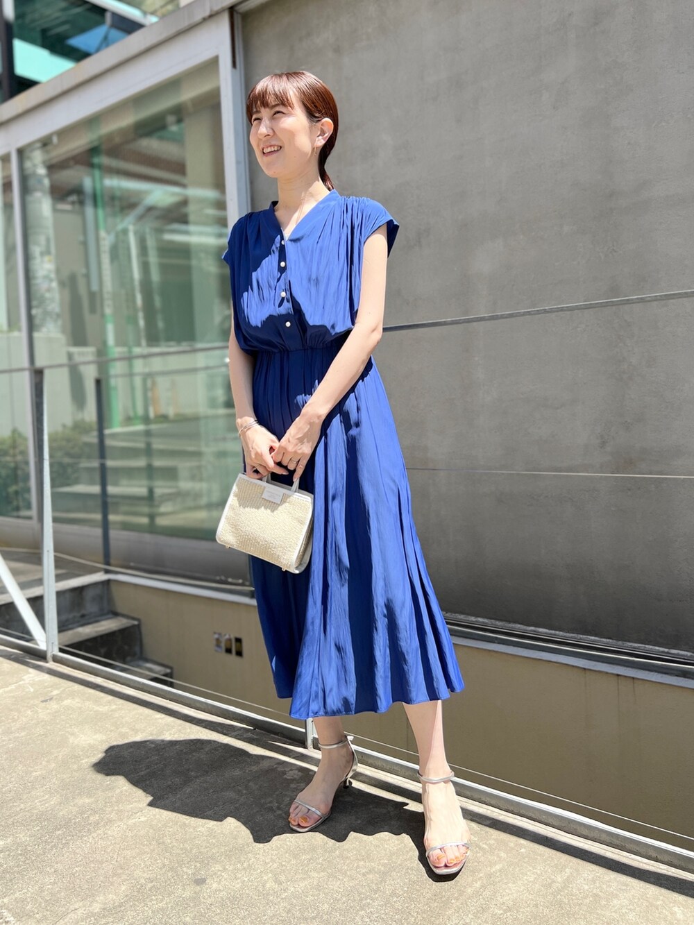 ホワイト系のトートバッグ、ブルー系のワンピース、ホワイト系のサンダルを着用したレディースの春コーディネートの7枚目の写真