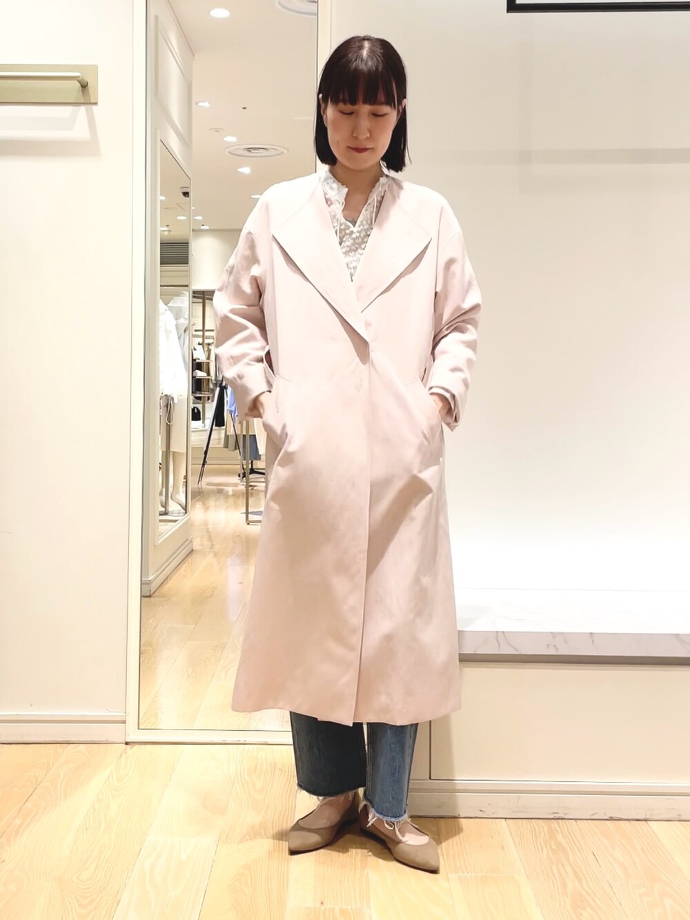 ベージュ系のニット/セーター、ピンク系のノーカラーコート、ホワイト系のシャツ/ブラウスを着用したレディースの春コーディネートの3枚目の写真