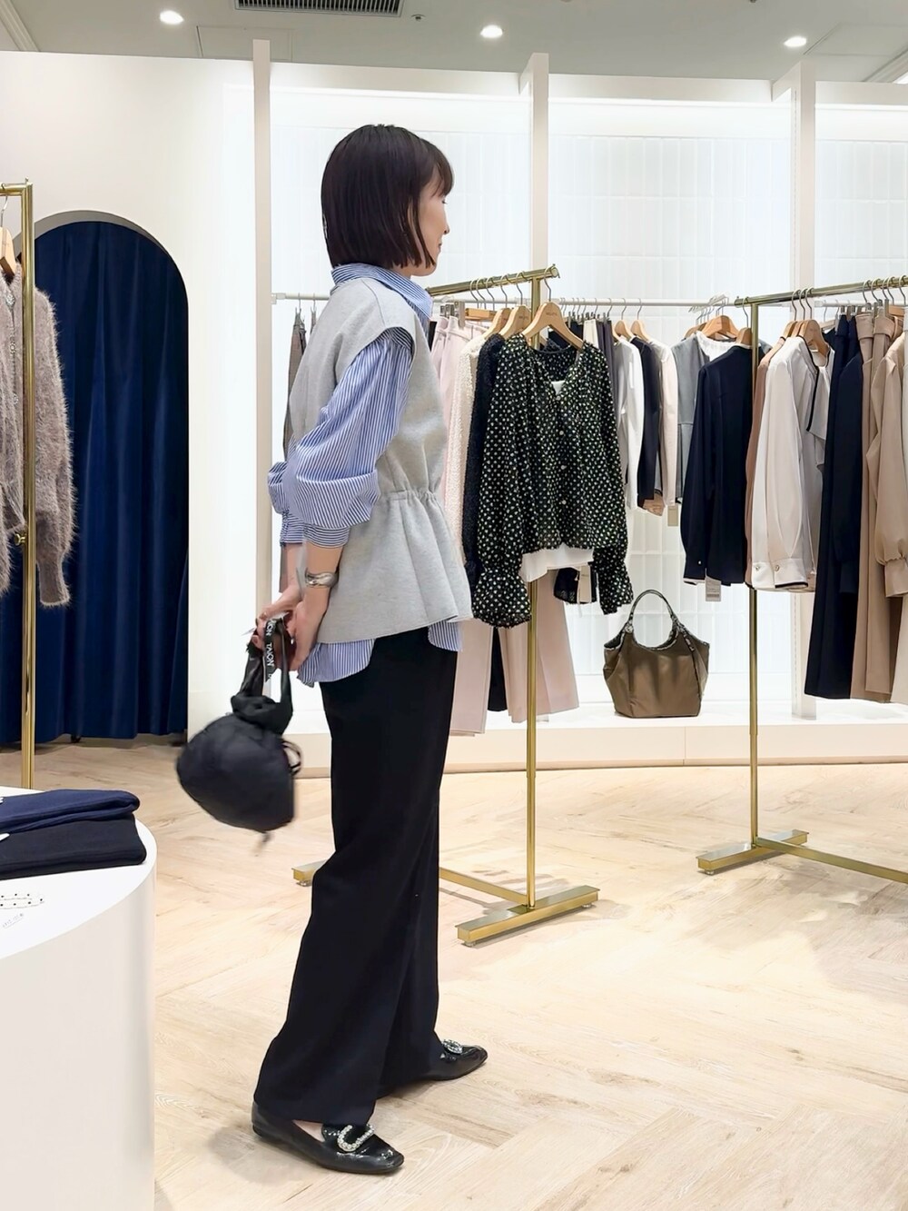 ブルー系のその他パンツ、グレー系のベスト、ブルー系のシャツ/ブラウスを着用したレディースの秋コーディネートの3枚目の写真