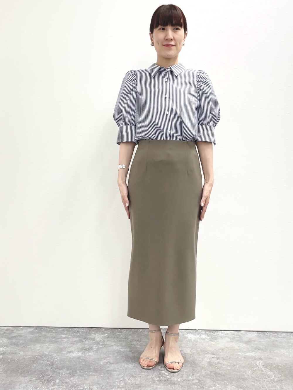 シルバー系のサンダル、グリーン系のスカート、ホワイト系のショルダーバッグを着用したレディースの春コーディネートの6枚目の写真